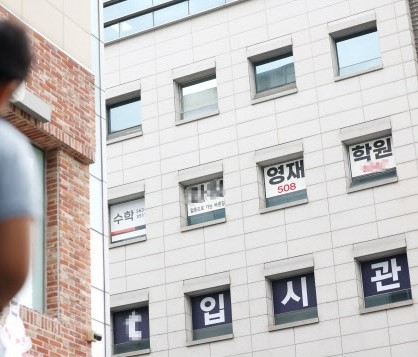 21일 서울 강남구 대치동 한 학원 건물 앞에 학생이 서 있다. 연합뉴스