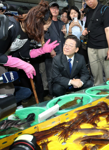 더불어민주당 이재명 대표가 22일 강원 강릉시 주문진 좌판풍물시장을 찾아 산오징어를 고르고 있다. 2023.6.22 연합뉴스