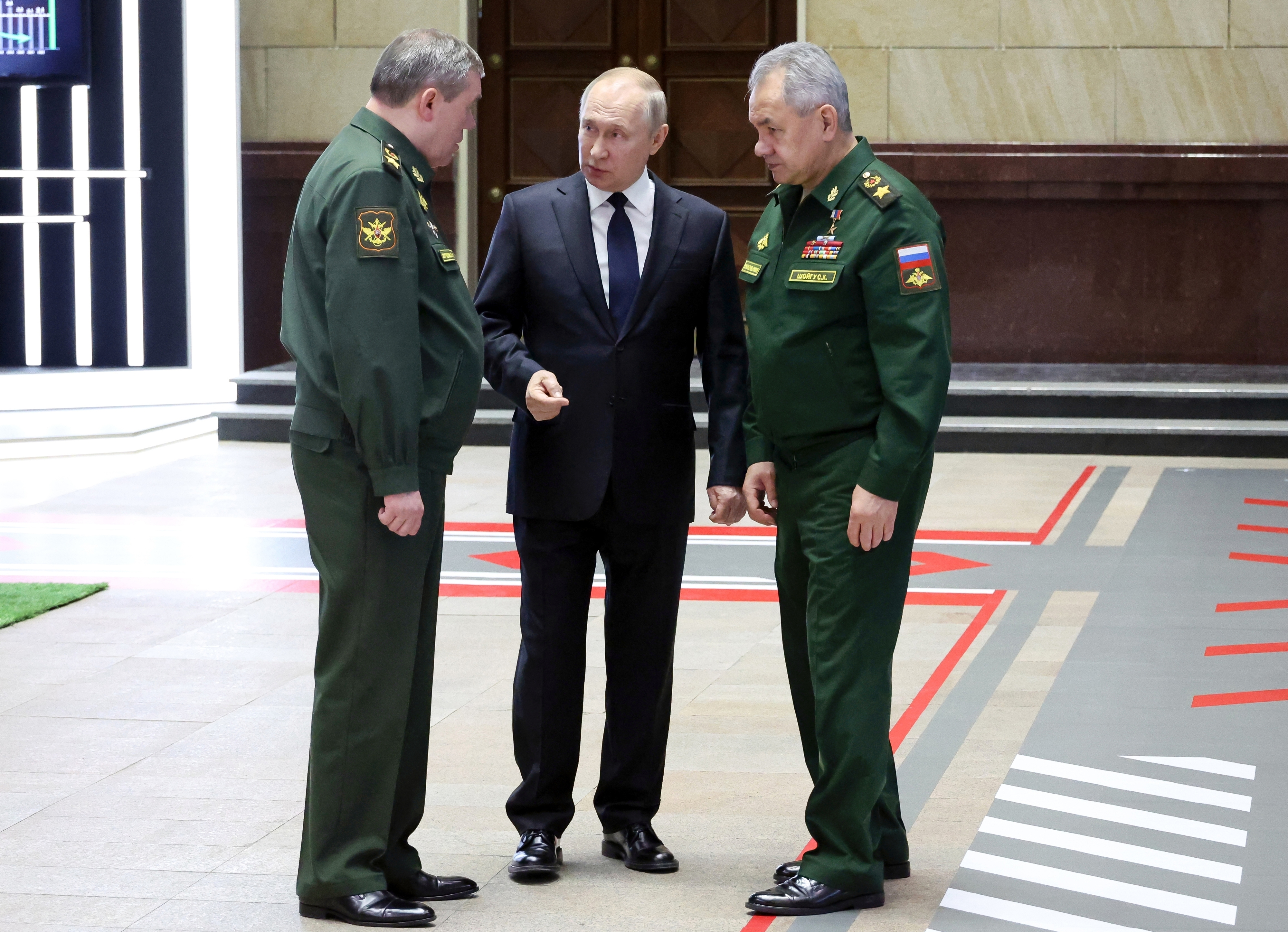 블라디미르 푸틴(가운데) 러시아 대통령이 21일(현지시간) 모스크바에서 고위 군 장교들과 회담을 마친 후 발레리 게라시모프(왼쪽) 총참모장과 세르게이 쇼이구(오른쪽) 국방장관과 대화하고 있다. 2022.12.21 스푸트니크/AP 연합뉴스