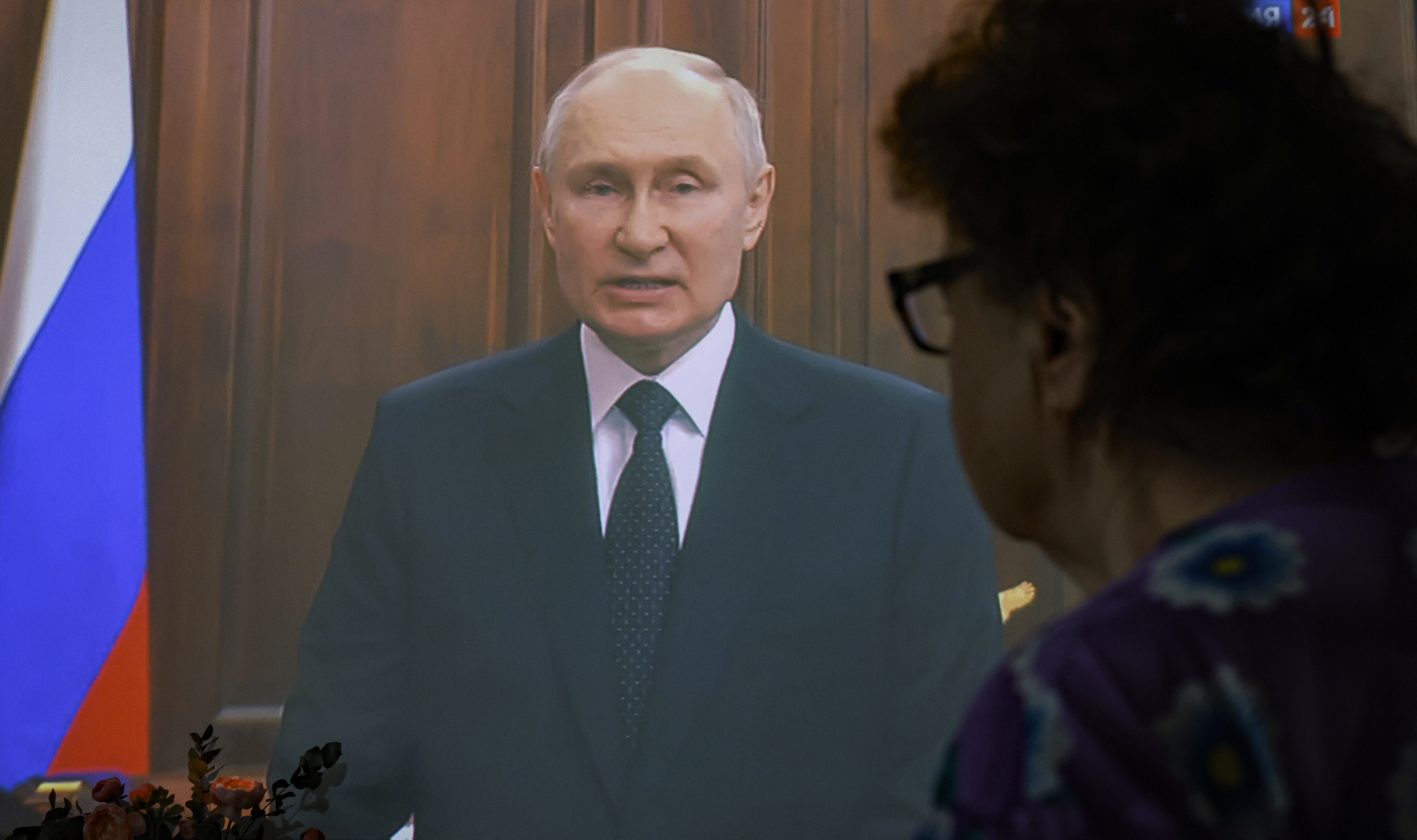 한 시민이 24일 러시아 모스크바에서 블라디미르 푸틴 러시아 대통령이 대국민 TV 연설을 하는 것을 지켜보고 있다. EPA 연합뉴스