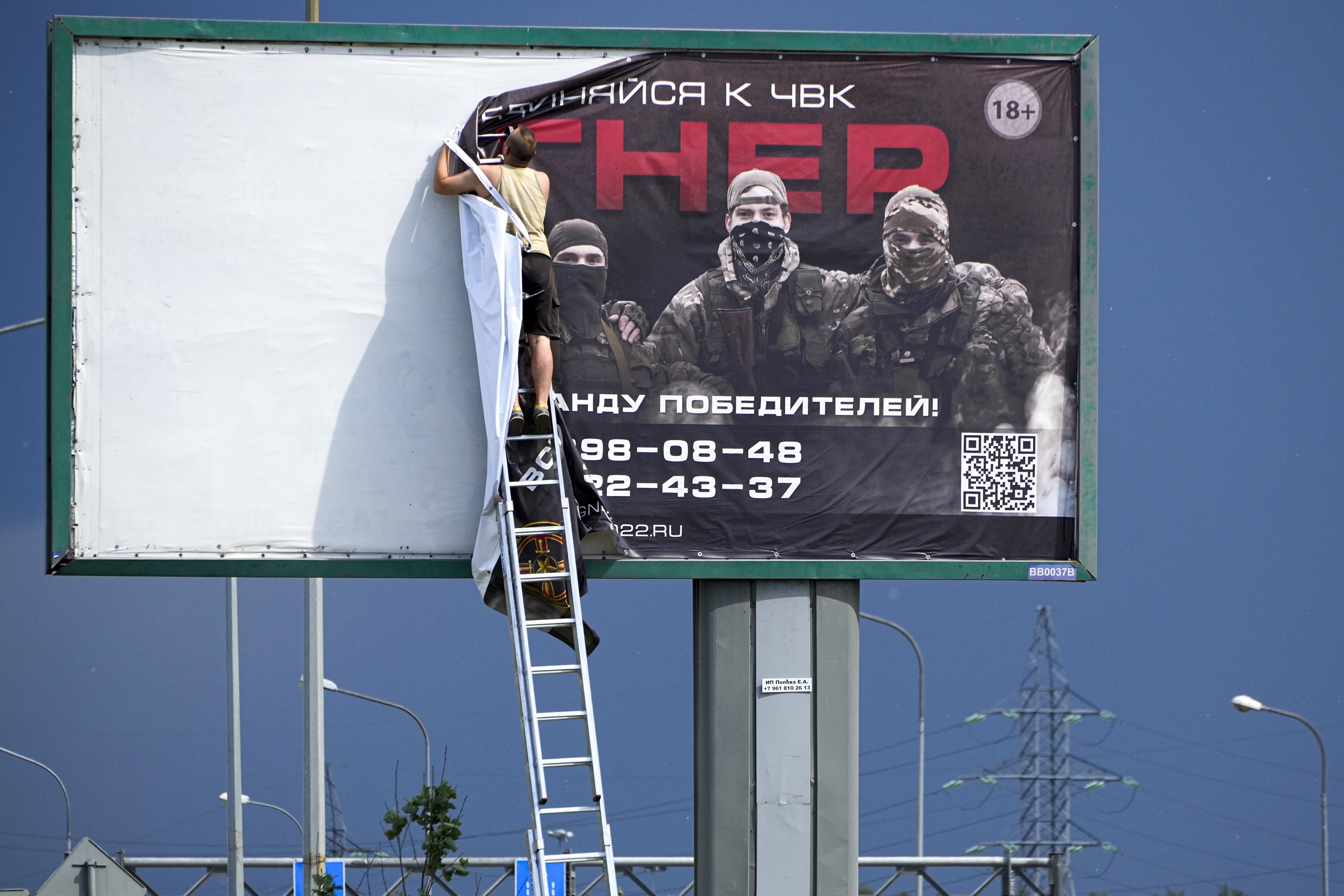 지난 6일 러시아 상트페테르부르크 외각 고속도로 위 광고판에서 한 남자가 바그너 그룹 용병 모집 현수막을 제거하고 있다. AP 연합뉴스