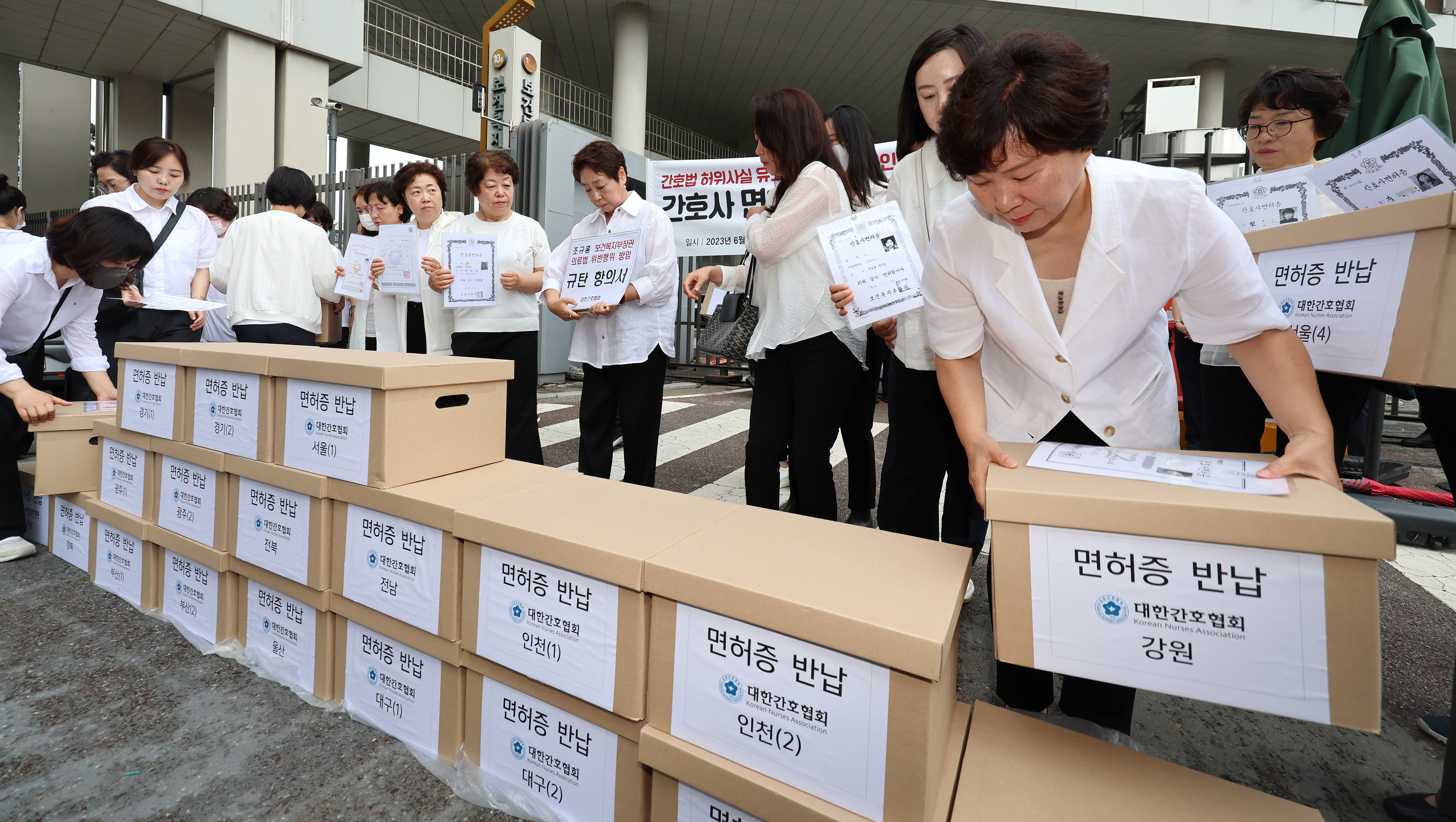 대한간호협회 소속 간호사 등이 26일 오전 세종시 정부세종청사 보건복지부앞에서 ‘간호법 허위사실 유포ㆍ불법진료 묵인 보건복지부 규탄’ 기자회견을 마친 뒤 간호사 면허증 반납을 위해 보건복지부 청사로 들어가고 있다.  연합뉴스