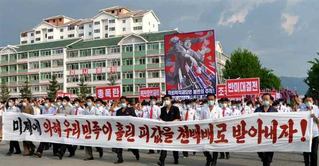 북한의 ‘6·25미제반대투쟁의 날’ 군중집회가 25일 각 도들에서 진행됐다고 26일 노동당 기관지 노동신문이 보도했다. 집회 참가자들이 ‘미제에 의해 우리 민족이 흘린 핏값을 천백배로 받아내자’는 문구가 적힌 현수막을 들고 행진하고 있다. 평양 노동신문 뉴스1