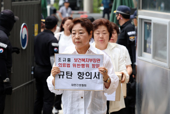 대한간호협회 소속 간호사 등이 26일 오전 세종시 정부세종청사 보건복지부앞에서 ‘간호법 허위사실 유포ㆍ불법진료 묵인 보건복지부 규탄’ 기자회견을 마친 뒤 간호사 면허증 반납을 위해 보건복지부 청사로 들어가고 있다. 2023.6.26 연합뉴스