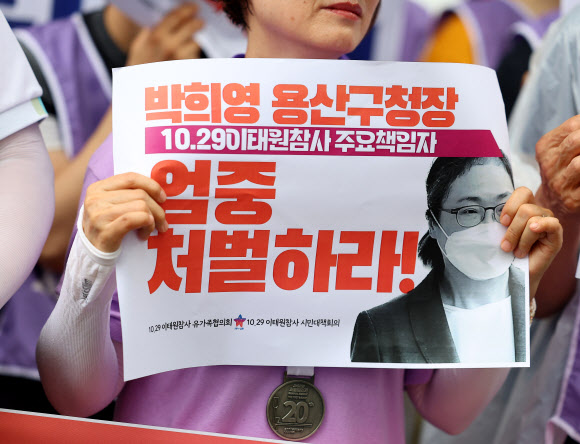 26일 오전 서울 마포구 서울서부지방법원 앞에서 열린 박희영 용산구청장 사퇴 및 엄중처벌 촉구 기자회견에서 한 참가자가 손팻말을 들고 있다. 지난 7일 보석으로 풀려났던 박희영 용산구청장은 이날 오후 10·29 이태원 참사 관련 재판에 출석한다. 2023.6.26 연합뉴스