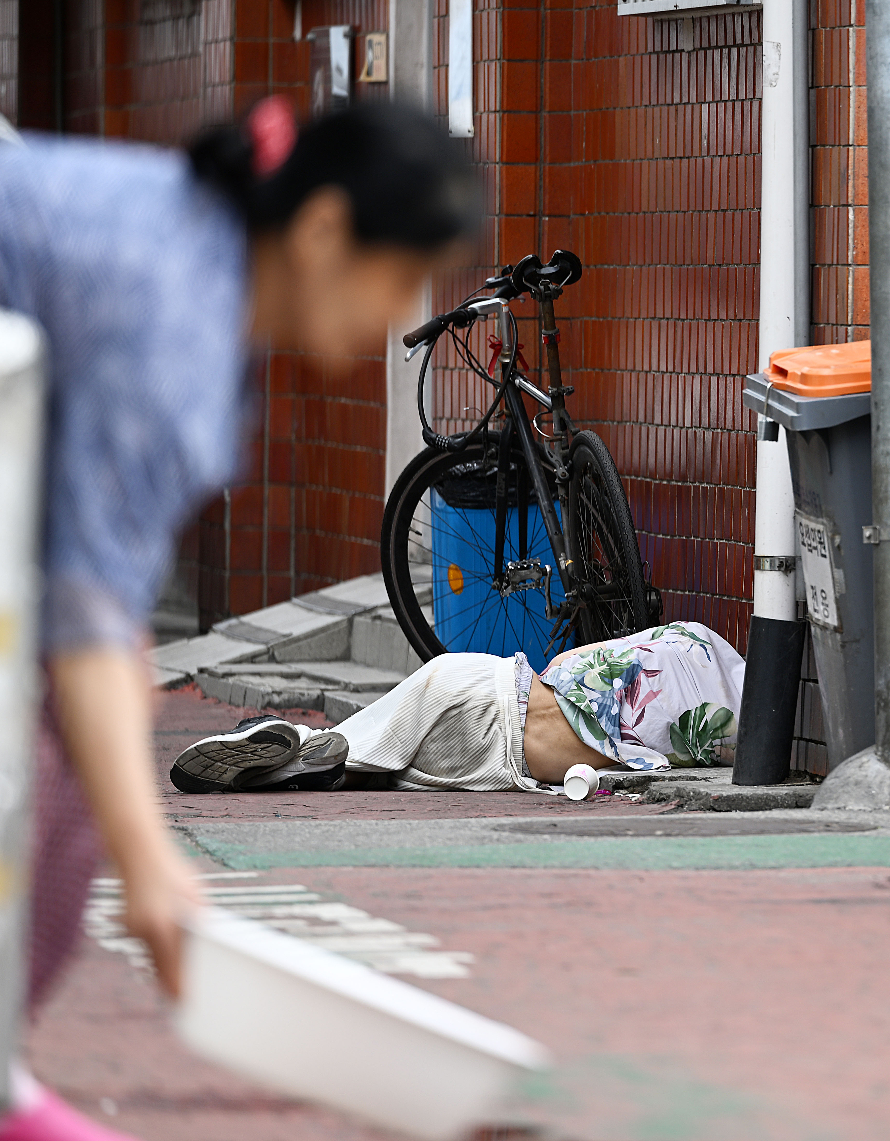 장마가 소강상태를 보여 후덥지근한 날씨가 관측되고 있는 27일 서울 영등포 쪽방촌에 한 노인이 길바닥에 누워 있다. 2023.6.27 오장환 기자