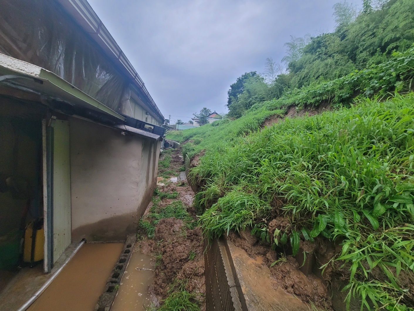 28일 오전 전북 순창군 유등면 한 야산에서 많은 비에 흙이 무너져내리면서 민가 뒤로 쏟아졌다. 전북소방본부 제공