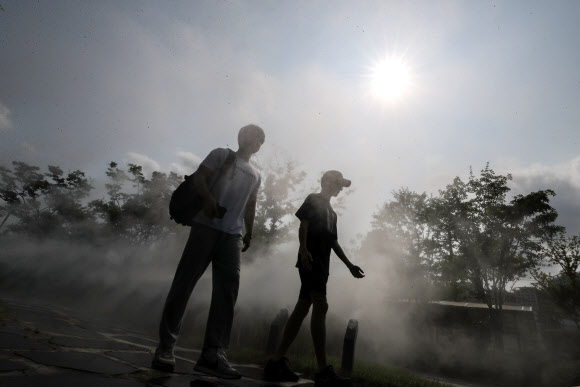 대구에 폭염주의보가 발효 중인 28일 오후 대구 중구 대봉동 인도에 설치된 쿨링포그 사이로 시민들이 더위를 식히며 걸어가고 있다. 2023.6.28 연합뉴스