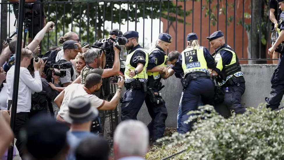 스웨덴 경찰이 지난 28일(현지시간) 스톡홀름에서 열린 시위 도중 이슬람 경전 쿠란을 불태우던 살완 모미카를 체포하자 시위 참가자들과 취재진이 카메라에 담으려 하고 있다. 스톡홀름 EPA 연합뉴스