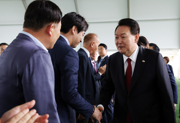 윤석열 대통령이 30일 경기 고양시 어울림누리 별무리경기장에서 열린 ‘서해선 대곡-소사 복선전철’ 개통 기념식에 입장하며 더불어민주당 한준호 의원과 인사하고 있다. 2023.6.30 연합뉴스