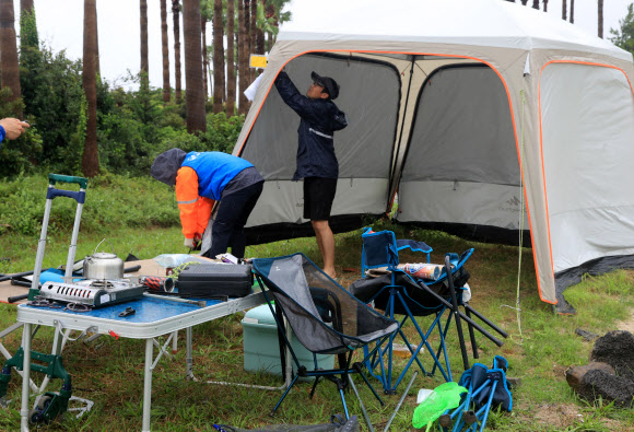 30일 오후 제주시 관계자 등이 제주시 금능해수욕장 야영장에 있는 ‘알박기’ 텐트를 강제 철거하고 있다. 협재·금능 해수욕장 야영장은 시민과 관광객이 효율적으로 사용할 수 있도록 7월 1일부터 8월 31일까지 지역 청년회에 위탁해 한시적으로 유료 운영된다. 2023.6.30 연합뉴스