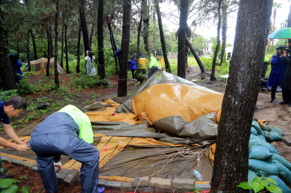 30일 오후 제주시 관계자 등이 제주시 협재해수욕장과 금능해수욕장 사이 녹지 지역에 있는 ‘알박기’ 텐트를 강제 철거하고 있다. 협재·금능 해수욕장 야영장은 시민과 관광객이 효율적으로 사용할 수 있도록 7월 1일부터 8월 31일까지 지역 청년회에 위탁해 한시적으로 유료 운영된다. 2023.6.30 연합뉴스