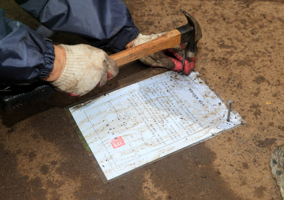 30일 오후 제주시 관계자 등이 제주시 협재해수욕장과 금능해수욕장 사이 녹지 지역에 있는 ‘알박기’ 텐트를 강제 철거하고 텐트가 있던 땅에 행정대집행 계고장을 못으로 박고 있다. 협재·금능 해수욕장 야영장은 시민과 관광객이 효율적으로 사용할 수 있도록 7월 1일부터 8월 31일까지 지역 청년회에 위탁해 한시적으로 유료 운영된다. 2023.6.30 연합뉴스