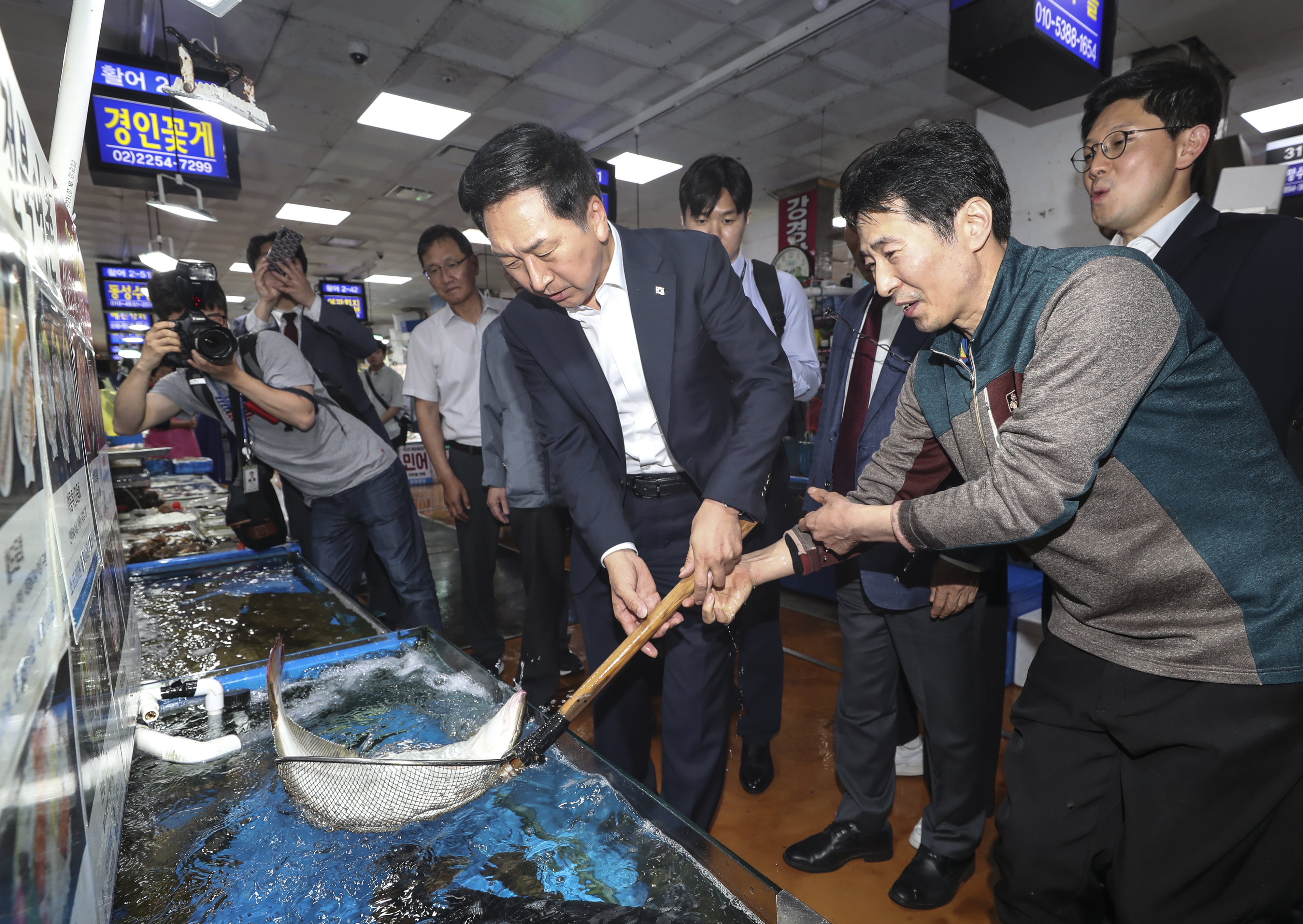국민의힘 김기현 대표가 15일 오후 서울 동작구 노량진수산시장을 방문해 뜰채로 광어를 들고 있다. 연합뉴스