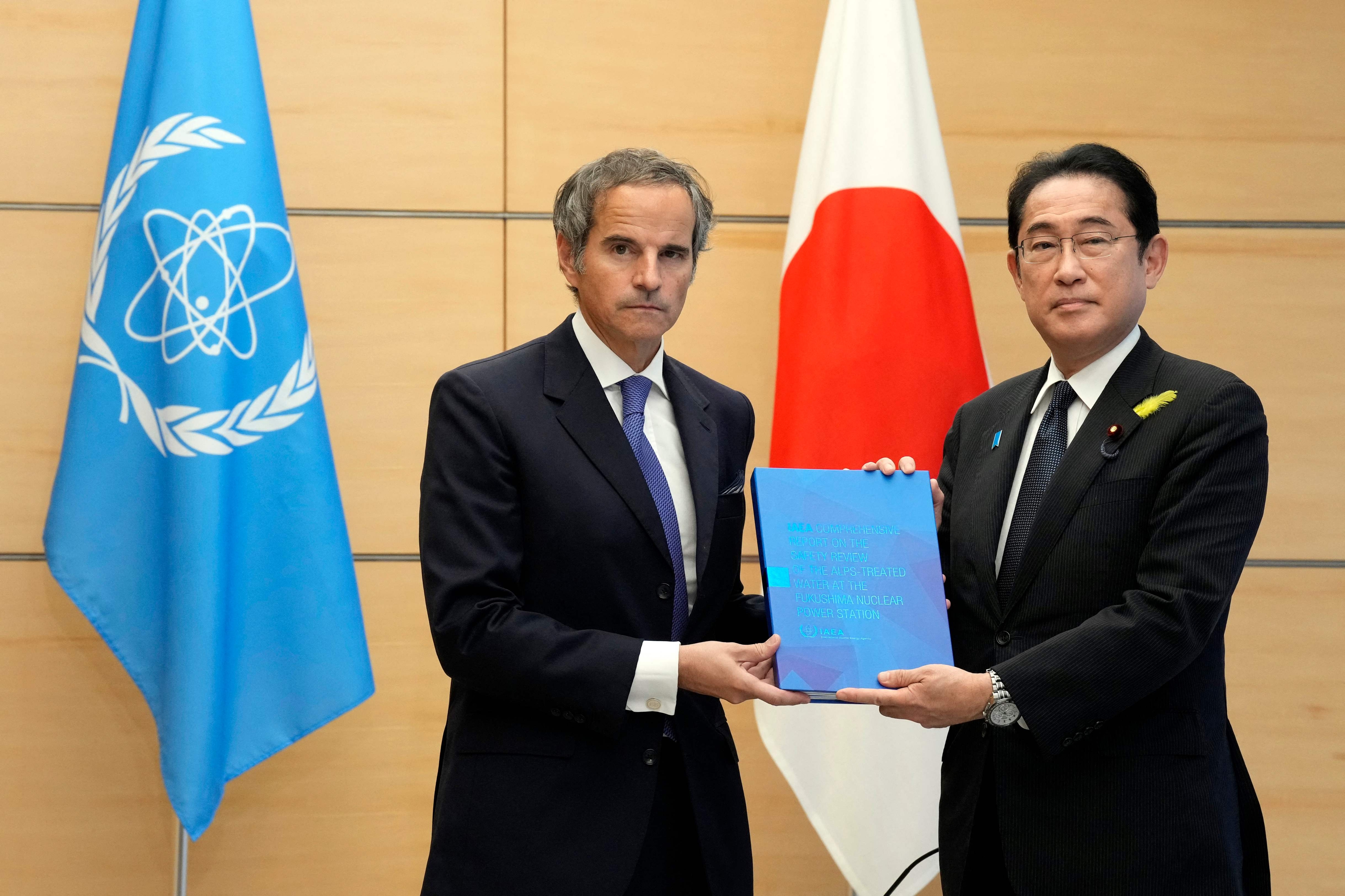 라파엘 그로시(왼쪽) 국제원자력기구(IAEA) 사무총장이 4일 일본 도쿄의 총리 관저에서 기시다 후미오 일본 총리에게 IAEA의 후쿠시마 오염수 방류 종합보고서를 전달하고 있다. AFP 연합뉴스