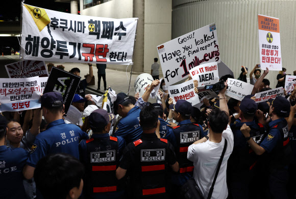 라파엘 그로시 국제원자력기구(IAEA) 사무총장의 입국이 예정된 7일 김포공항 국제선 입국장 인근에서 시민단체가 그로시 사무총장의 방한을 반대하는 손 피켓을 들고 있다. 2023.7.7 연합뉴스