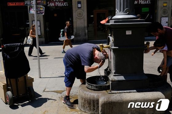 스페인 바르셀로나를 달군 폭염에 한 시민이 분수대에서 머리를 감고 있다. 바르셀로나 로이터 뉴스1