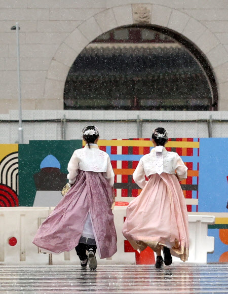 9일 오전 서울 종로구 광화문광장에 갑자기 소나기가 쏟아지자 한복을 입은 관광객들이 비를 피해 뛰어가고 있다. 2023.7.9 연합뉴스