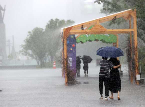 9일 오전 서울 종로구 광화문광장에 갑자기 소나기가 내리자 시민들이 우산을 쓰고 걸어가고 있다. 2023.7.9 연합뉴스