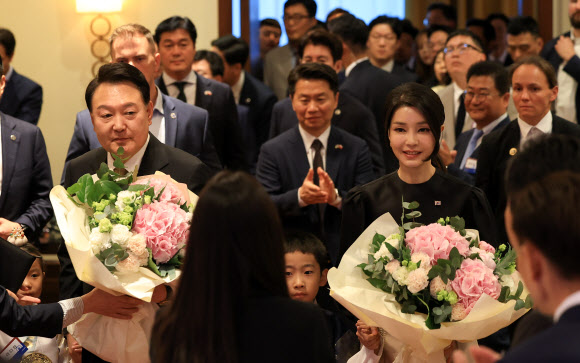폴란드를 공식 방문한 윤석열 대통령과 김건희 여사가 12일(현지시간) 바르샤바 한 호텔에서 열린 동포간담회에서 화동으로부터 받은 꽃다발을 들고 있다. 2023.7.13. 공동취재
