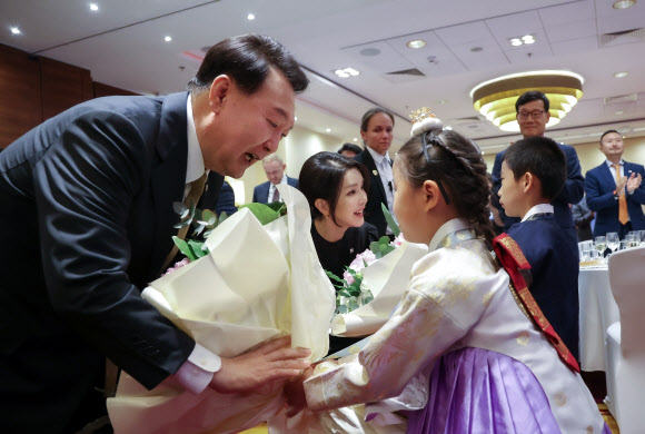 폴란드를 공식 방문한 윤석열 대통령과 김건희 여사가 12일(현지시간) 바르샤바 한 호텔에서 열린 동포간담회에서 화동으로부터 꽃다발을 받고 있다. 2023.7.13 연합뉴스