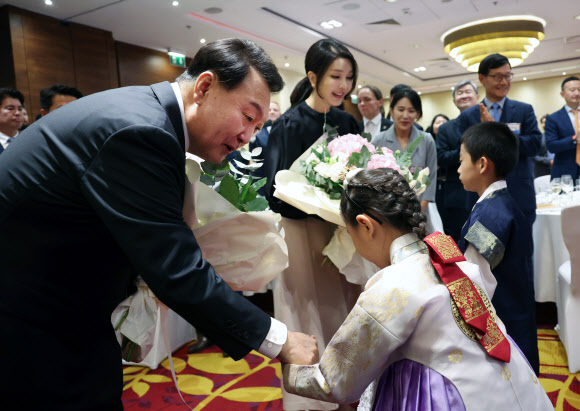 폴란드를 공식 방문한 윤석열 대통령과 김건희 여사가 12일(현지시간) 바르샤바 한 호텔에서 열린 동포간담회에서 화동으로부터 꽃다발을 받고 있다. 2023.7.13 연합뉴스
