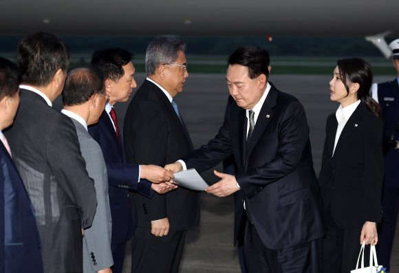 리투아니아에서 열린 북대서양조약기구(NATO·나토) 정상회의 참석과 폴란드·우크라이나 방문을 마친 윤석열 대통령이 17일 성남 서울공항을 통해 귀국, 국민의힘 김기현 대표가 준비한 수해 관련 자료를 살펴보며 대화하고 있다. 2023.7.17 연합뉴스