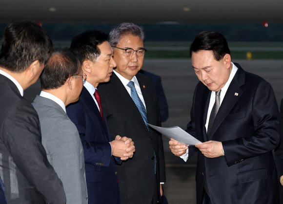 리투아니아에서 열린 북대서양조약기구(NATO·나토) 정상회의 참석과 폴란드·우크라이나 방문을 마친 윤석열 대통령이 17일 성남 서울공항을 통해 귀국, 국민의힘 김기현 대표가 준비한 수해 관련 자료를 살펴보며 대화하고 있다. 2023.7.17 연합뉴스