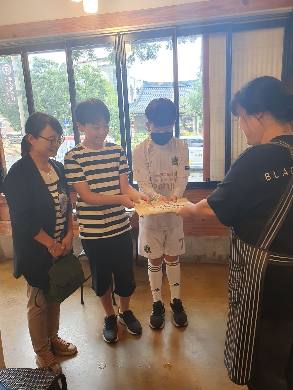 전주 풍남초 학생들이 전주 한옥마을의 한 음식점을 찾아 간판 변경을 건의하는 편지를 전달했다. 전북도교육청 제공