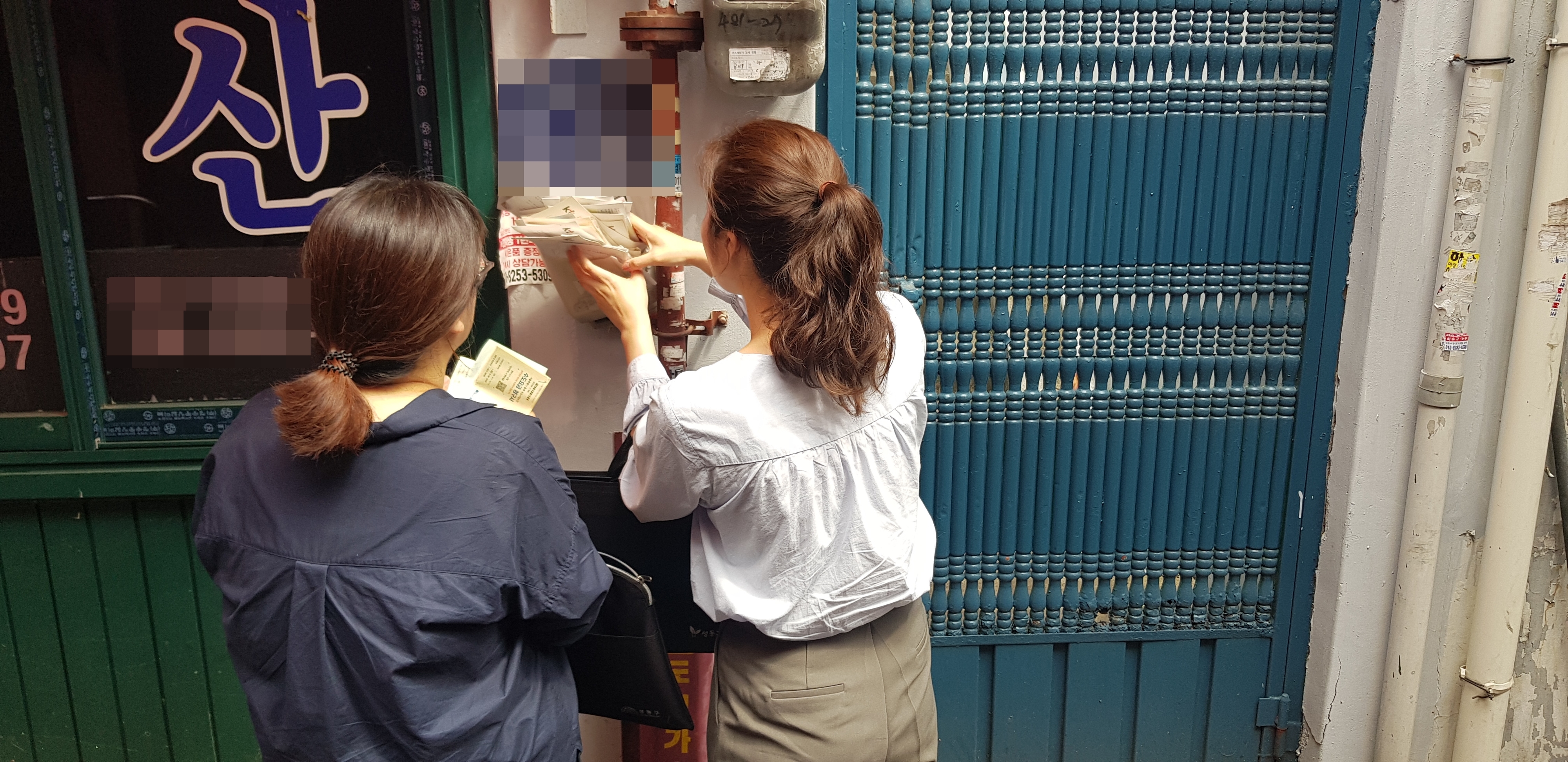 서울 성동구 마장동주민센터 복지팀 공무원들이 지난 5월 30일 위기 의심가구로 분류된 한 다세대주택의 우편함을 확인하고 있다. 카드 고지서, 통신비 명세서 등을 통해 의심가구로 분류된 주민이 실제로 이곳에 사는지를 파악하기 위해서다.  홍인기 기자