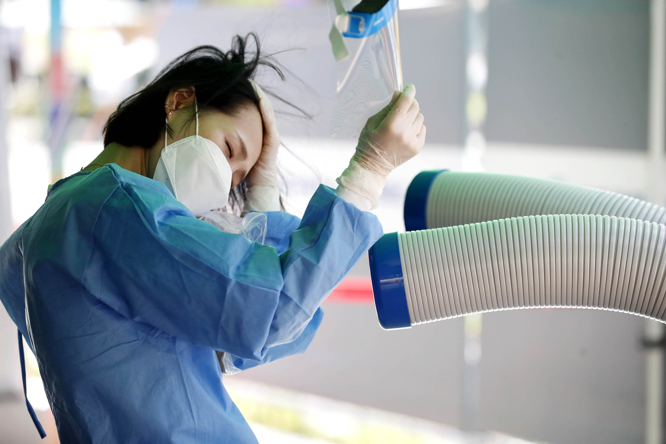 6일 오후 광주 북구 코로나19 선별진료소에서 보건소 의료진이 냉풍기 앞에서 땀을 닦고 있다. 2023.7.6 광주 북구 제공