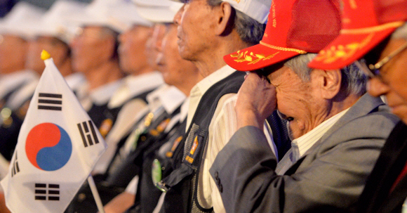 6·25전쟁 65주년 행사에 참석한 한 참전용사가 태극기를 들고 눈물을 흘리고 있다. 박지환 기자