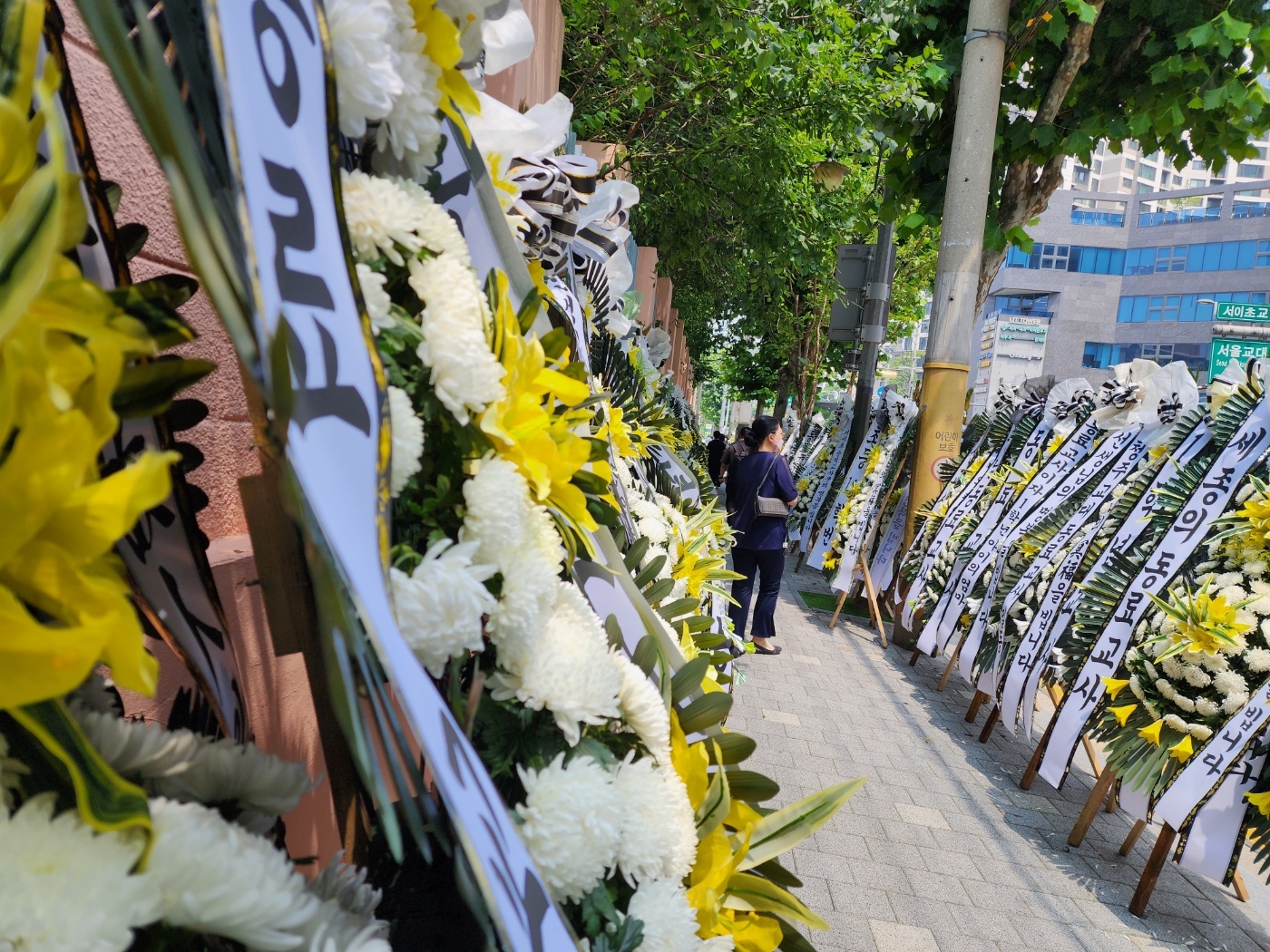 지난 18일 학교에서 초등학교 교사가 극단적 선택을 한 서울 서초구 한 초등학교 정문 앞 길가를 근조화환이 가득 메우고 있다. 김중래 기자