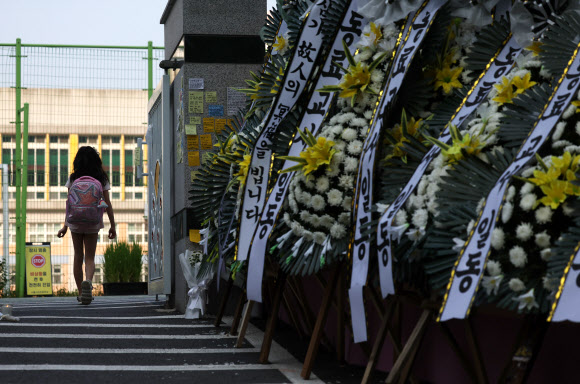 20일 오전 서초구 한 초등학교 앞에 추모 화환들이 가득 놓여 있다.    교육계에 따르면 이 학교 담임 교사 A씨가 학교 안에서 극단적 선택을 해 숨지는 일이 발생했다. 2023.7.20 연합뉴스