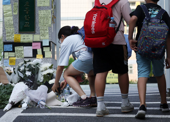 20일 오전 서초구 한 초등학교 앞에 등굣길 학생이 헌화를 하고 있다.   교육계에 따르면 이 학교 담임 교사 A씨가 학교 안에서 극단적 선택을 해 숨지는 일이 발생했다. 2023.7.20 연합뉴스