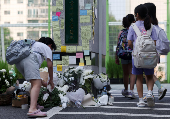 20일 오전 서초구 한 초등학교 앞에 등굣길 학생이 헌화를 하고 있다.   교육계에 따르면 이 학교 담임 교사 A씨가 학교 안에서 극단적 선택을 해 숨지는 일이 발생했다. 2023.7.20 연합뉴스