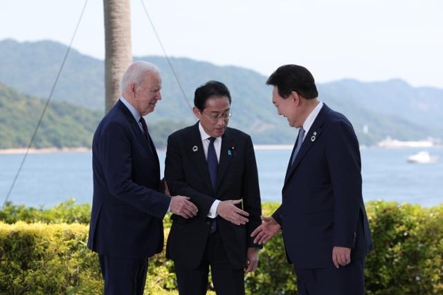 윤석열 대통령과 조 바이든(왼쪽) 미국 대통령, 기시다 후미오(가운데) 일본 총리가 지난 5월 21일 일본 히로시마에서 열린 주요 7개국(G7) 정상회의장인 그랜드 프린스 호텔에서 열린 한미일 정상회담에서 악수를 나누고 있다. 대통령실 제공