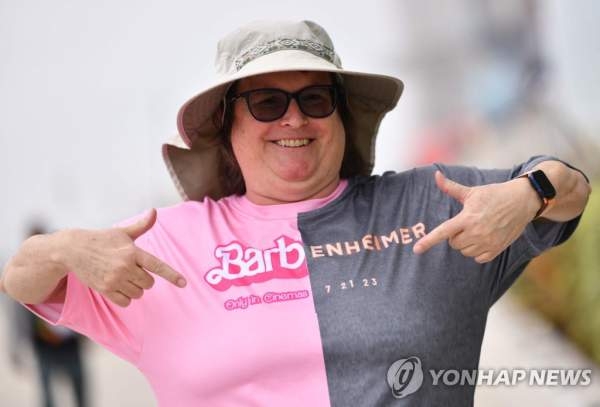 ‘바벤하이머’ 셔츠를 입고 좋아라 하는 미국 영화 팬. 핑크빛 인형 세상과 핵폭발 잿빛 세상이 대조를 이룬다. AFP 자료사진 연합뉴스