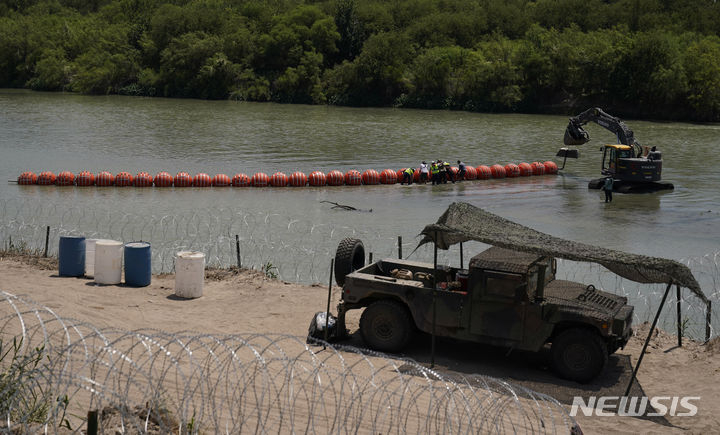 텍사스주가 멕시코와의 국경인 리오그란데 강 위에 설치하는 부표 국경선을 작업자들이 조립하고 있다. 이글 패스 AP 뉴시스
