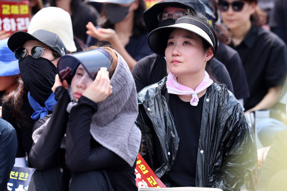 29일 서울 종로구 경복궁역 사거리 인근에서 열린 공교육 정상화를 위한 집회에서 한 참가자가 고인이 된 서이초 담임교사를 위한 추모영상을 보며 눈시울을 붉히고 있다. 2023.7.29 연합뉴스
