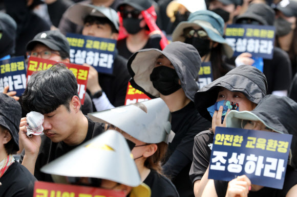 29일 오후 서울 종로구 정부서울청사 앞에서 열린 서이초 교사 추모 및 공교육 정상화 촉구 집회에서 한 참가자가 추모 영상을 보다 눈물을 흘리고 있다. 2023.07.29. 뉴시스