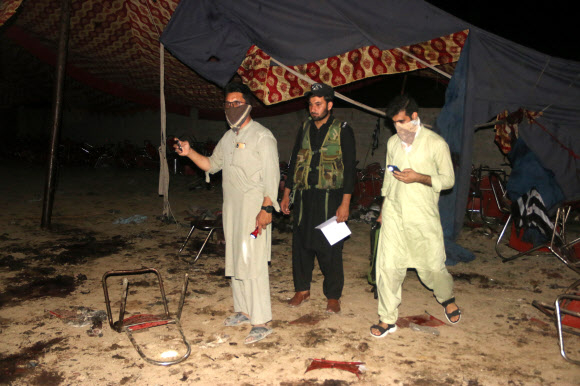 사람들이 30일(현지시간) 파키스탄 북서부 바자우르 지구 카르란 마을에서 열린 이슬람 정당 자미앗 울마에이슬람 파지(JUI-F) 집회 도중 자살폭탄 테러로 보이는 공격 때문에 적어도 37명이 죽고 100명이 다친 현장을 조사하고 있다. 카르 EPA 연합뉴스