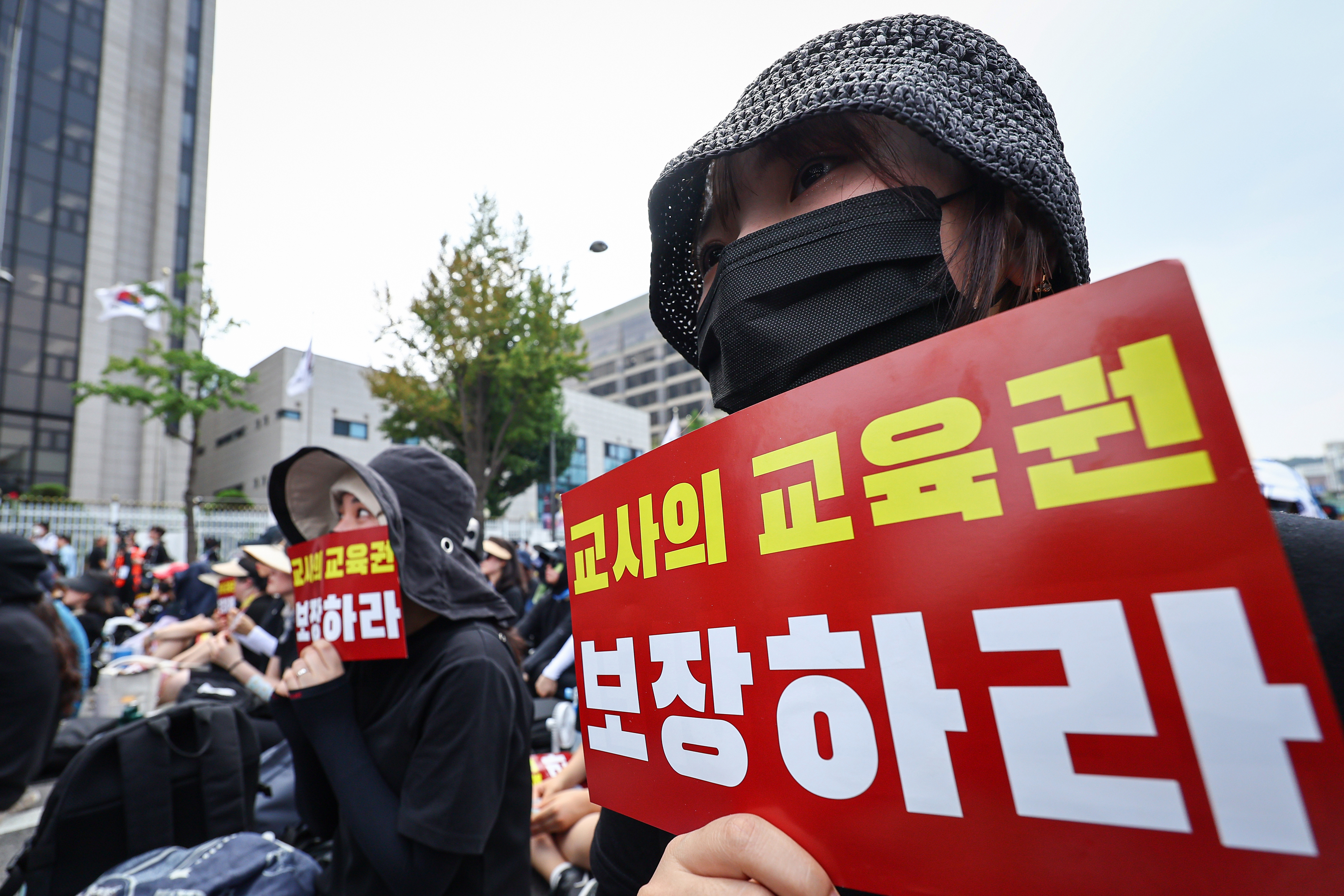 전국 각지에서 모인 교사들이 지난달 29일 서울 종로구 경복궁역 사거리 인근에서 열린 공교육 정상화를 위한 집회에 참석해 팻말을 들고 있다. 연합뉴스