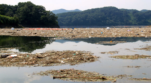 충북 옥천군 군북면 석호리 대청호에 장마 때 떠내려온 쓰레기가 거대한 섬을 이뤄 수면 위에 둥둥 떠 있다. 한국수자원공사 대청댐관리단은 쓰레기 수거에 2주일가량이 더 걸릴 것으로 내다봤다.2023.7.31 연합뉴스