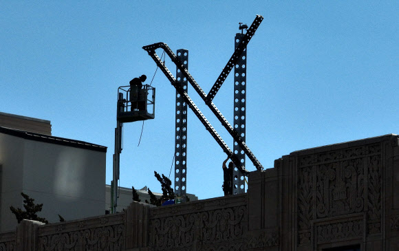 미국 캘리포니아주 샌프란시스코에 있는 X 본사 건물 옥상에 설치돼 있던 대형 구조물 철거 작업이 31일(현지시간) 아침 시작돼 일꾼들이 일하고 있다. 샌프란시스코 AFP 연합뉴스