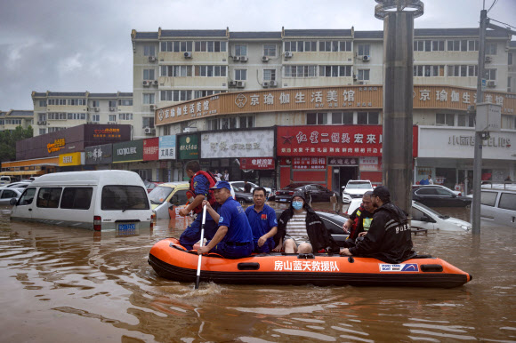 중국 구조대가 1일 보트에 사람들을 태우고 폭우로 잠긴 베이징 거리를 빠져나가고 있다. 이날 중국 관영 매체는 베이징에 사흘째 폭우가 이어지며 11명이 숨지고 27명이 실종됐다고 보도했다. 베이징 로이터 연합뉴스