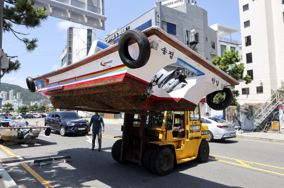 제6호 태풍 ‘카눈’이 한반도를 향해 북상 중인 7일 부산 해운대구 송정어촌계 어민들이 중장비를 이용해 어선을 옮기고 있다. 2023.8.7 연합뉴스