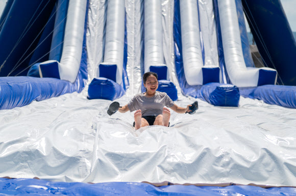 2023 새만금 세계스카우트 잼버리 행사가 한창인 지난 6일 한 청소년 대원이 물 미끄럼틀을 타고 있다. 2023.8.7. 세계스카우트연맹 제공