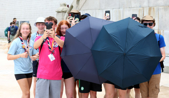 7일 오후 서울 종로구 경복궁에서 2023 새만금 세계 스카우트 잼버리에서 조기 퇴영한 영국 스카우트 대원들이 취재진을 촬영하고 있다. 2023.8.7 연합뉴스