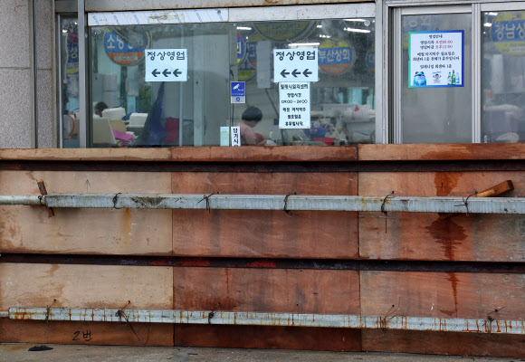 제6호 태풍 ‘카눈’이 북상하고 있는 9일 부산 수영구 민락수변공원에 있는 회센터 출입문에 월파에 대비해 차수판이 설치돼 있다. 2023.8.9 연합뉴스